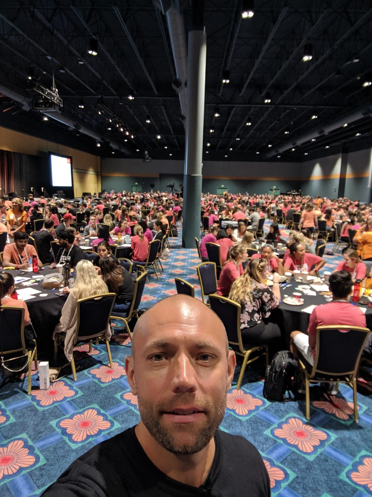 Joe Lalley at a large conference session with hundreds of attendees seated at round tables